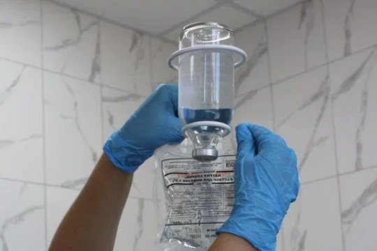 Медсестра настраивает капельницу для процедуры УБОД