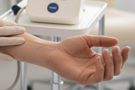 Рука мужчины, которому врач измеряет артериальное давление