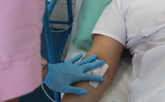 Сотрудник медперсонала ставит капельницу для снятия ломки пациенту в клинике