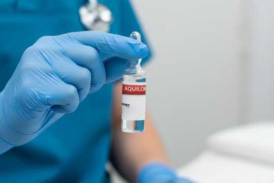 Врач держит в руке ампулу с препаратом Аквилонг