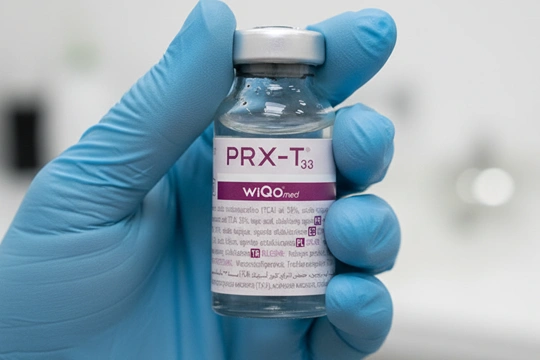 Доктор держит в руке флакон с препаратом для пилинга prx t-33