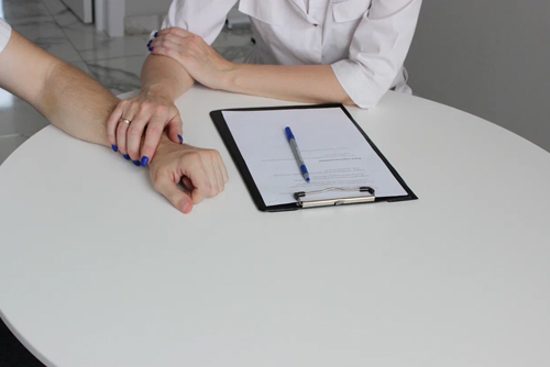 Врач-нарколог держит пациента за руку