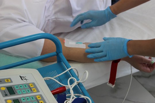 Врач ставит капельницу пациенту в реабилитационном центре