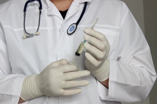 Врач стоит со шприцом в руках